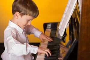 young-boy-passionately-plays-piano-showcasing-talent-and-joy-in-a-warm-inviting-setting